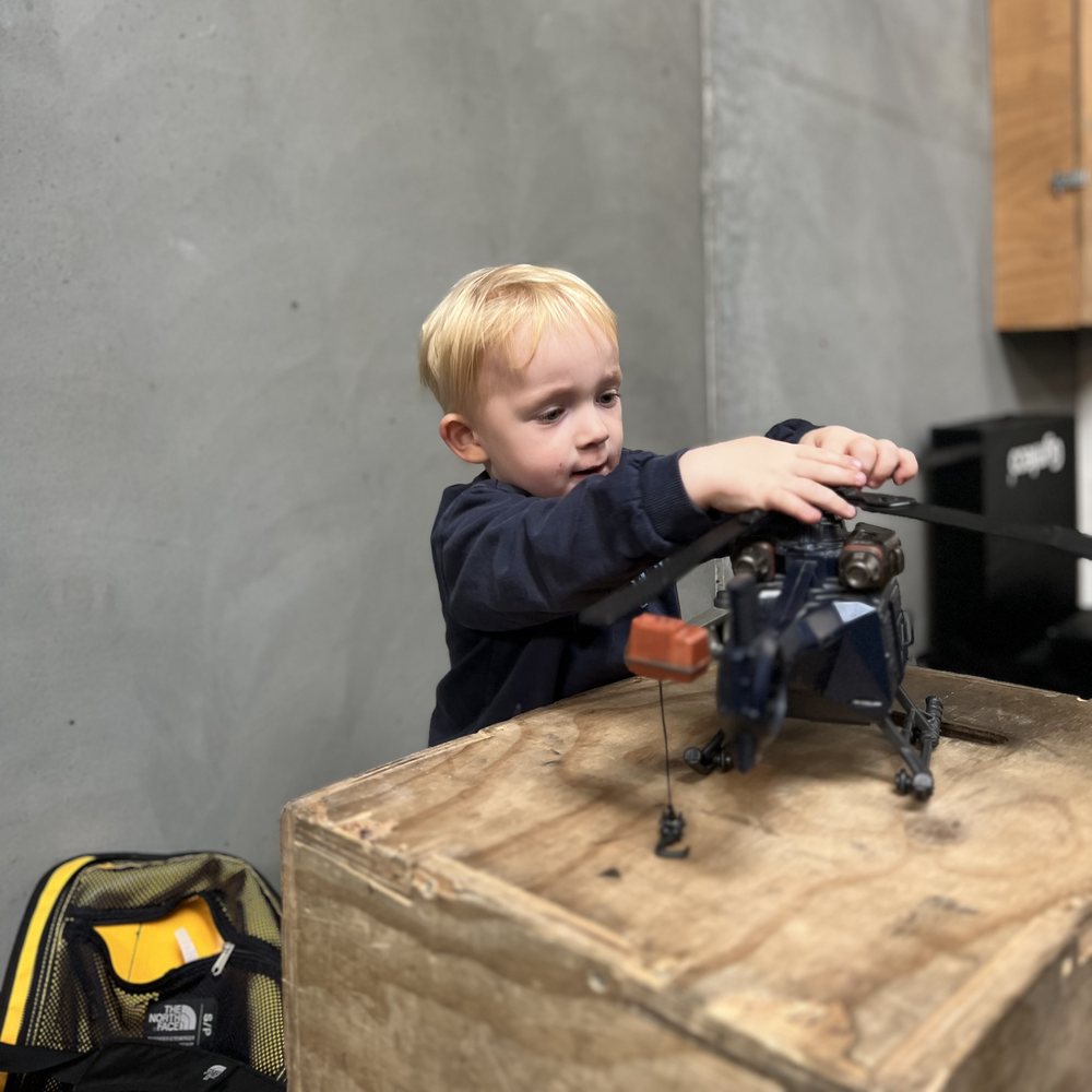 Barn leger med en helikopter i boxen