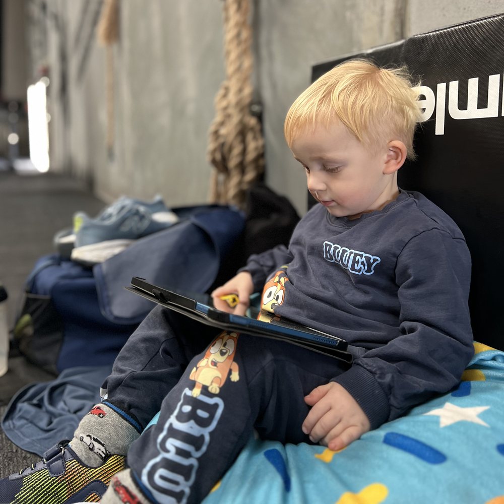 Barn med en iPad i en sækkestol i boxen